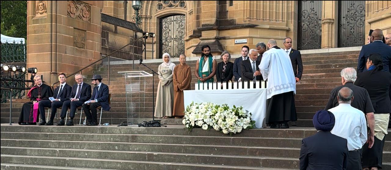 Faith and community leaders gathered together on the steps of a cathedral